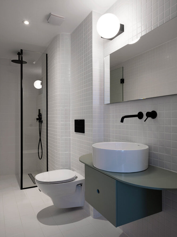 white tiles clad the bathrooms