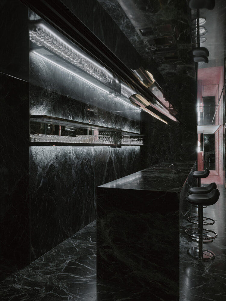 mirrored ceilings amplify the monolithic presence of the bar