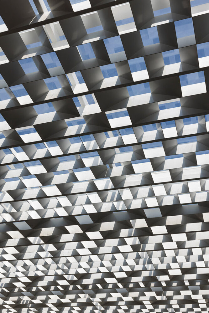 the west-facing facade is equipped with light steel shades composed of angled panels