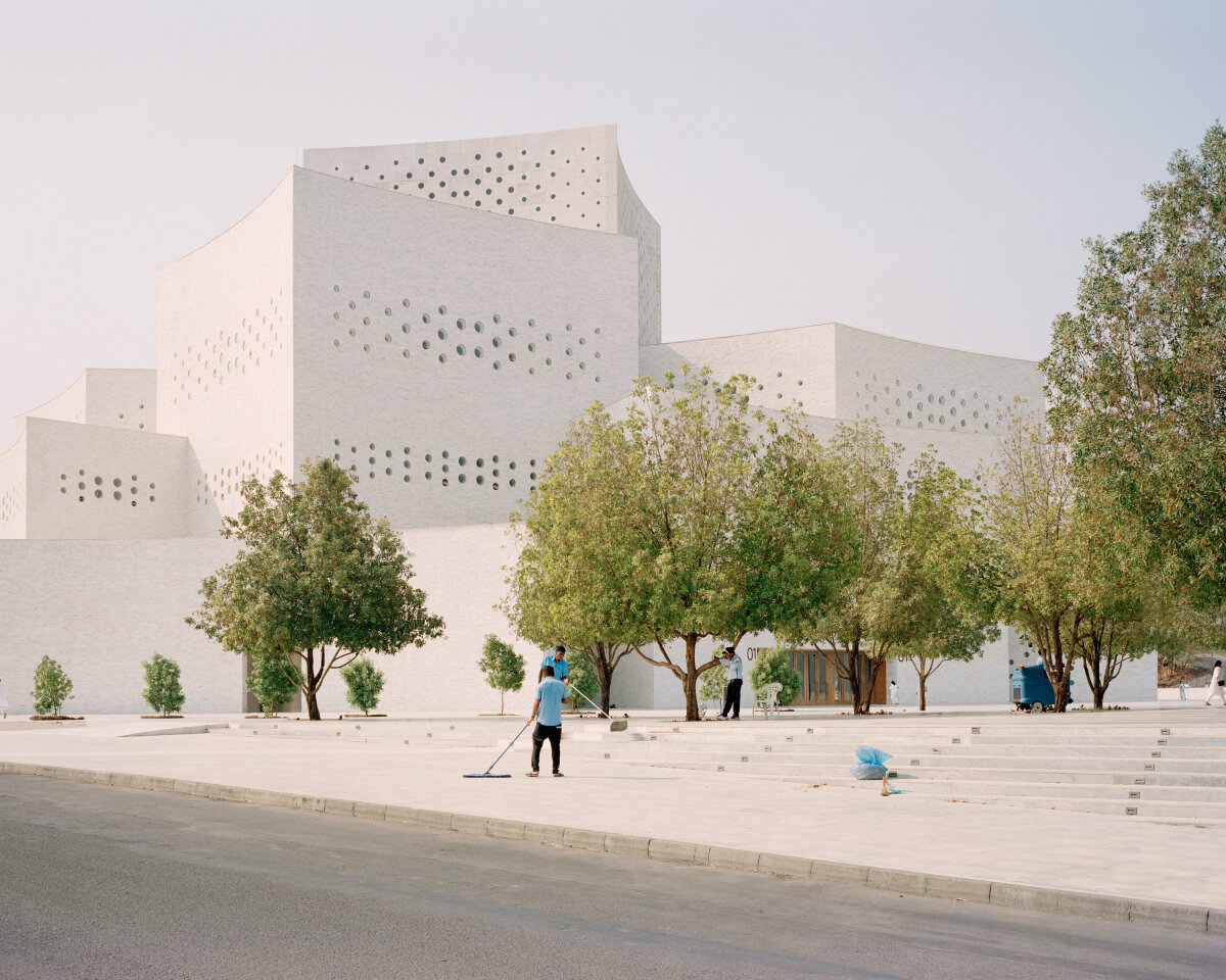 sequence of curved white marble volumes shape serie architects' ashram auditorium in india
