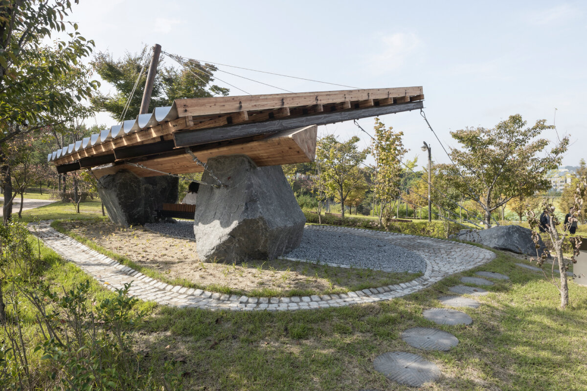SO? rests wood & metal canopy atop rocks for 'urban interior' pavilion in south korea