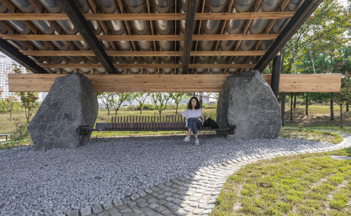 SO? rests wood & metal canopy atop rocks for 'urban interior' pavilion in south korea