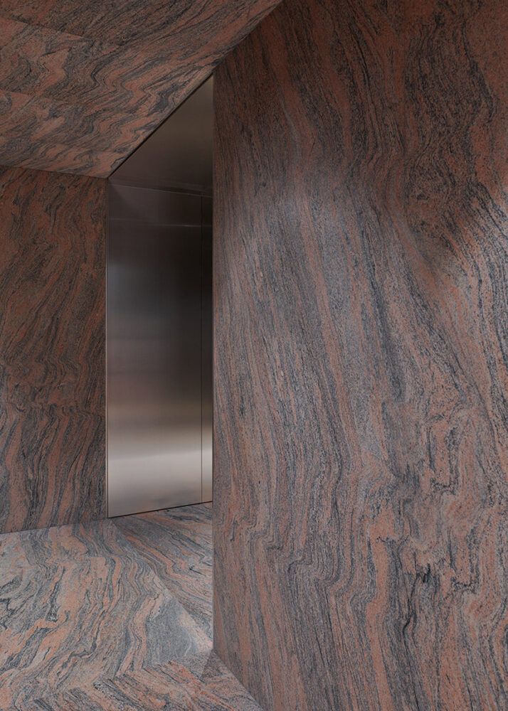 visitors step into a futuristic stainless steel tunnel that opens into a cavernous room