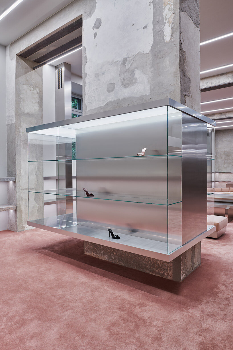 a custom glass bookcase hosts the archive of the brand and doubles as a display