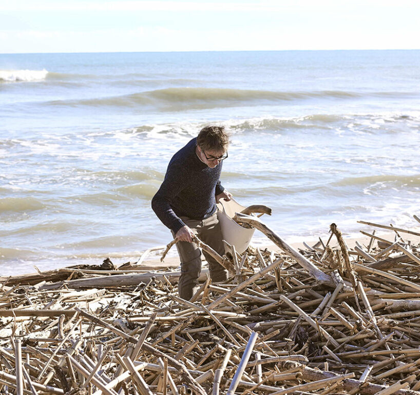 Héctor picking up roots dragged by the DANA from the beaches of Valencia