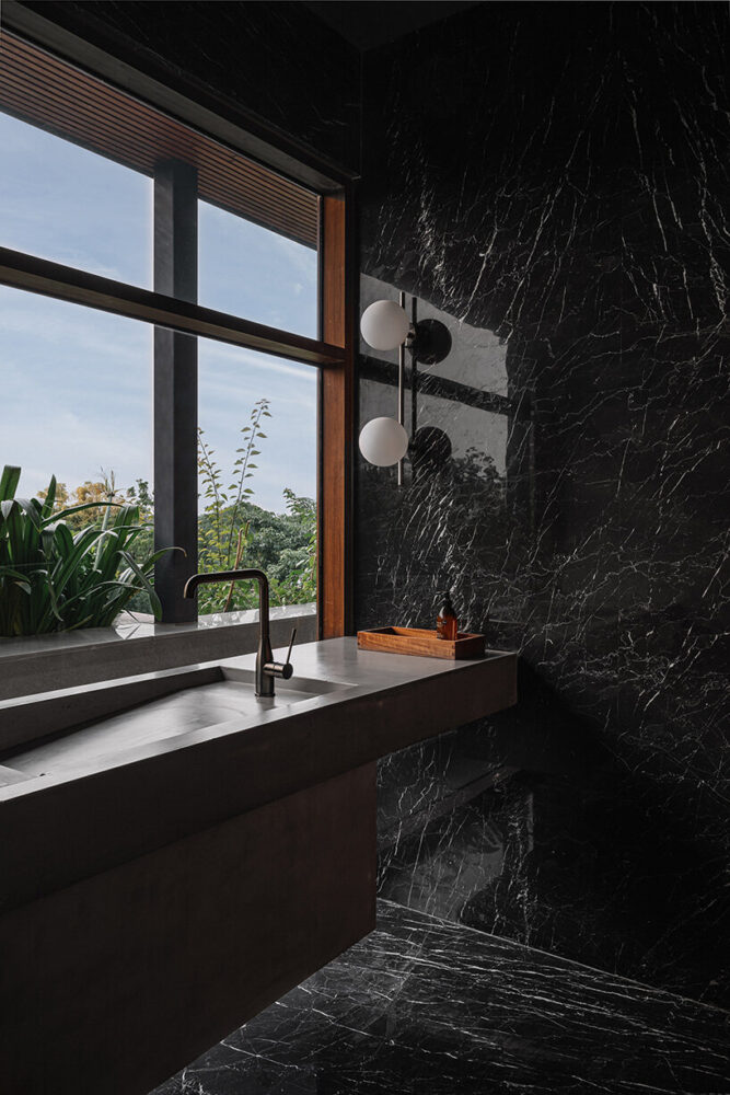 the black powder room on the terrace overlooks an array of Champa trees