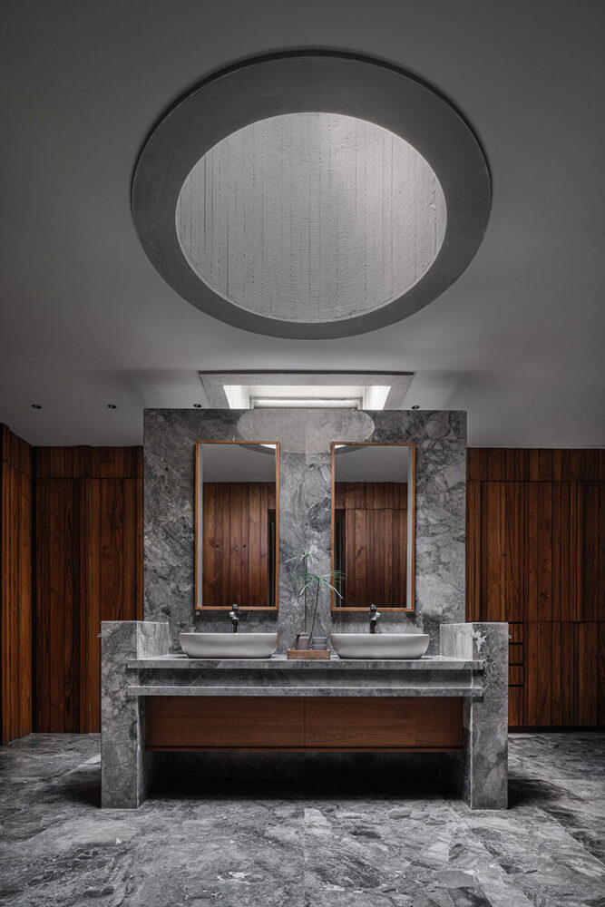 marble and wood textures complete the bathroom