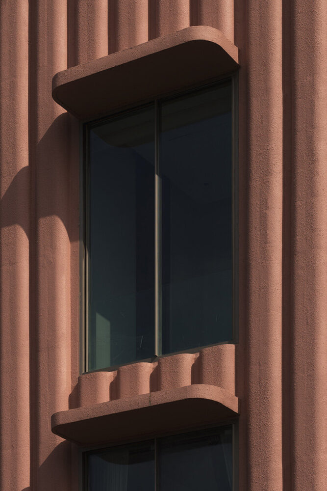 concrete flutings and fluid overhangs soften Satguru’s Rendezvous’ massing