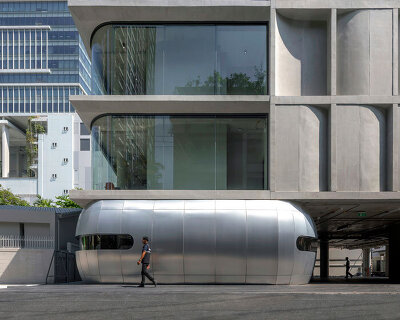 ASWA installs golf driver-like steel entrance along curved concrete panel facade in bangkok