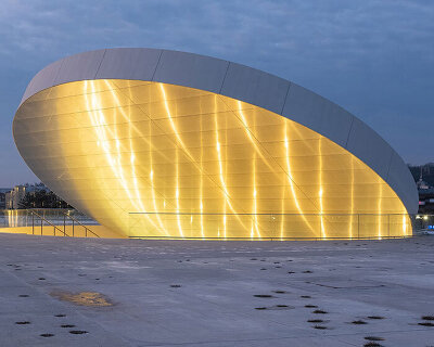 tilted reflective disk sits atop SMAR's science island museum in nemunas, lithuania