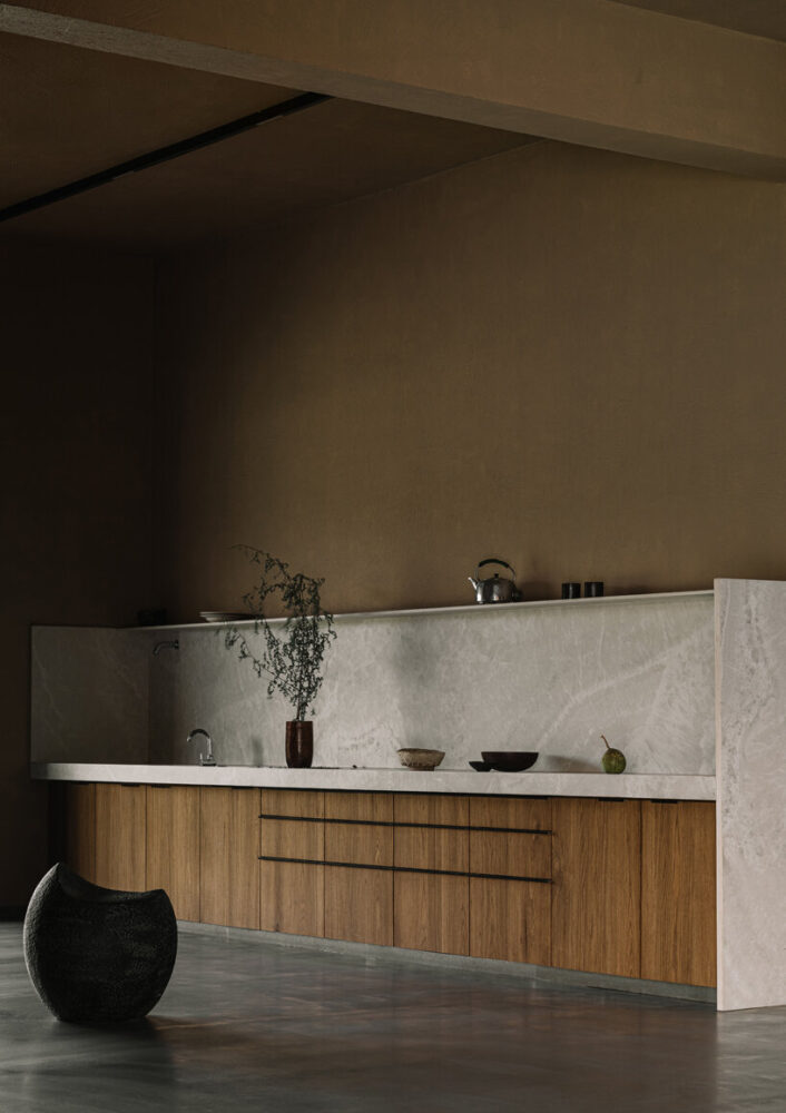 stone meets wood in minimalist kitchen, highlighting a refined material palette