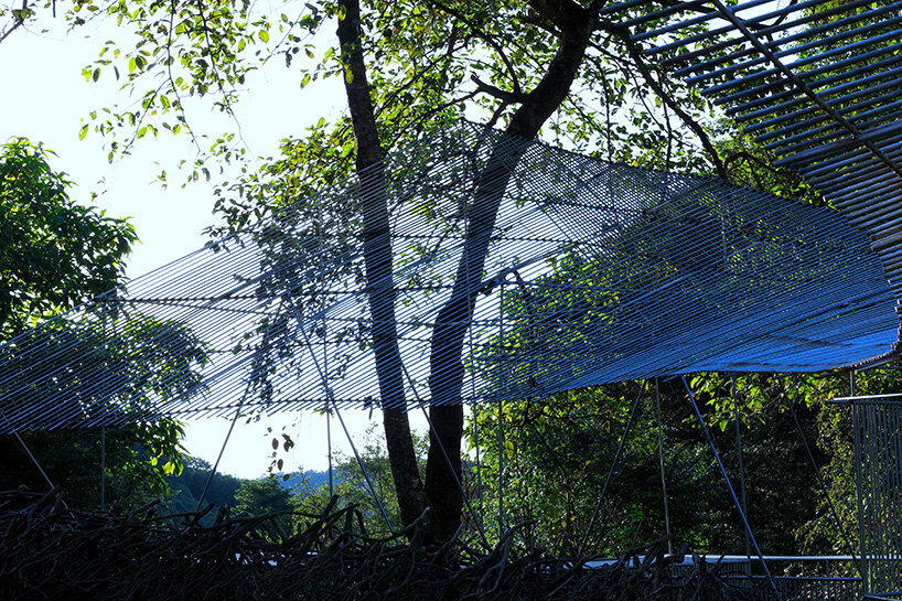 inside the open-air structure, birdwatchers sit in contemplative silence