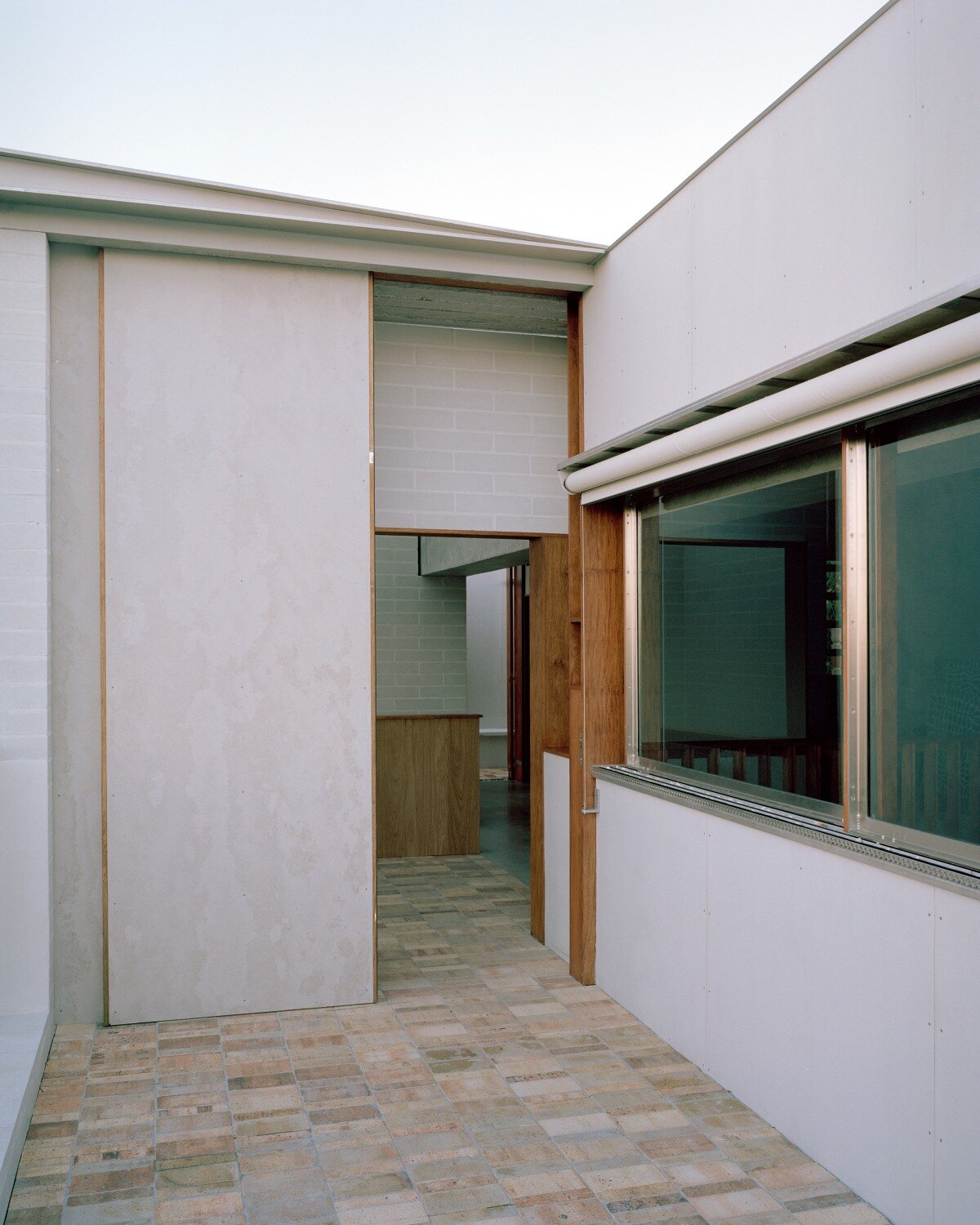 salvaged terracotta, bricks, and metal nets wrap around peter besley's australian house