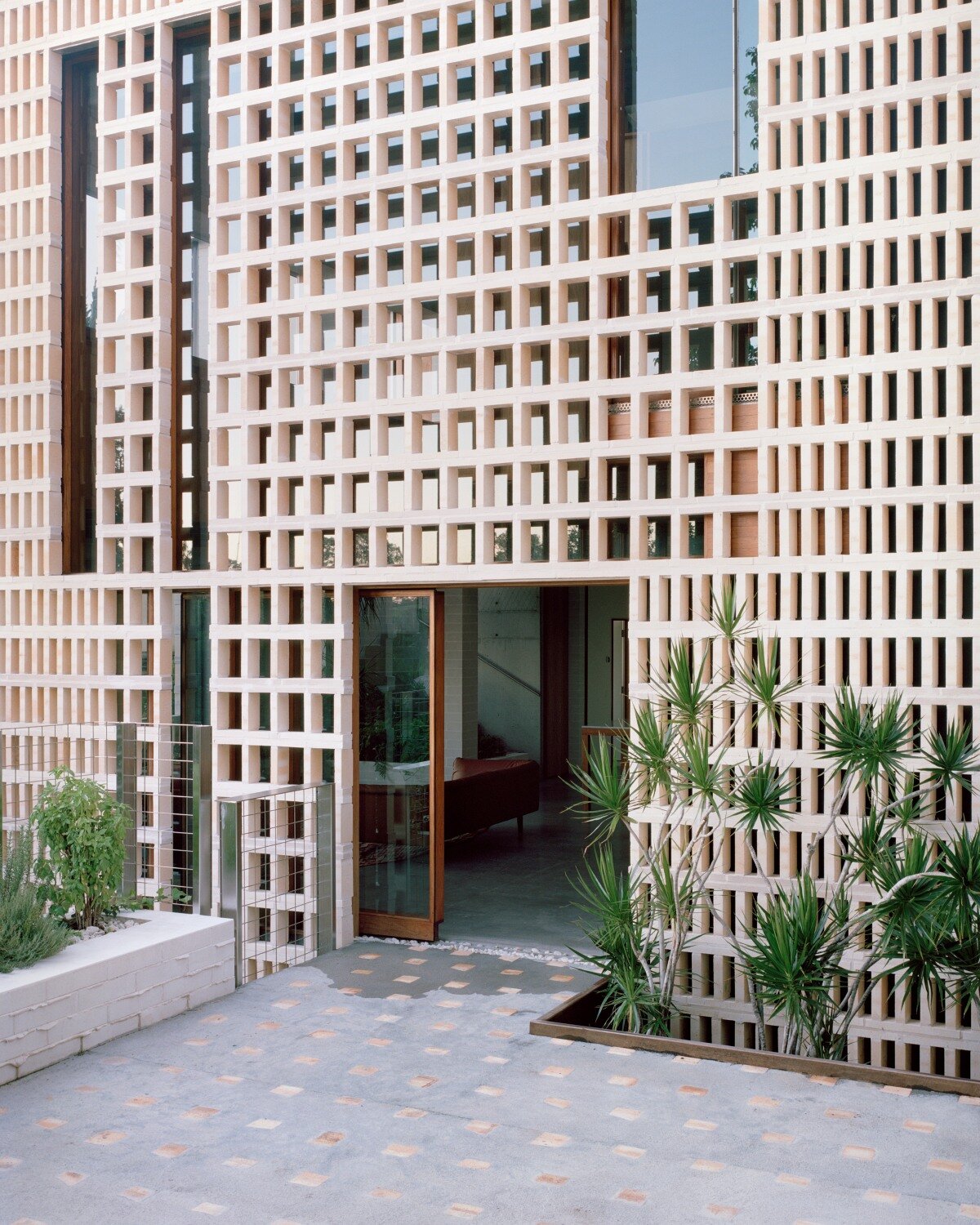 salvaged terracotta, bricks, and metal nets wrap around peter besley's australian house