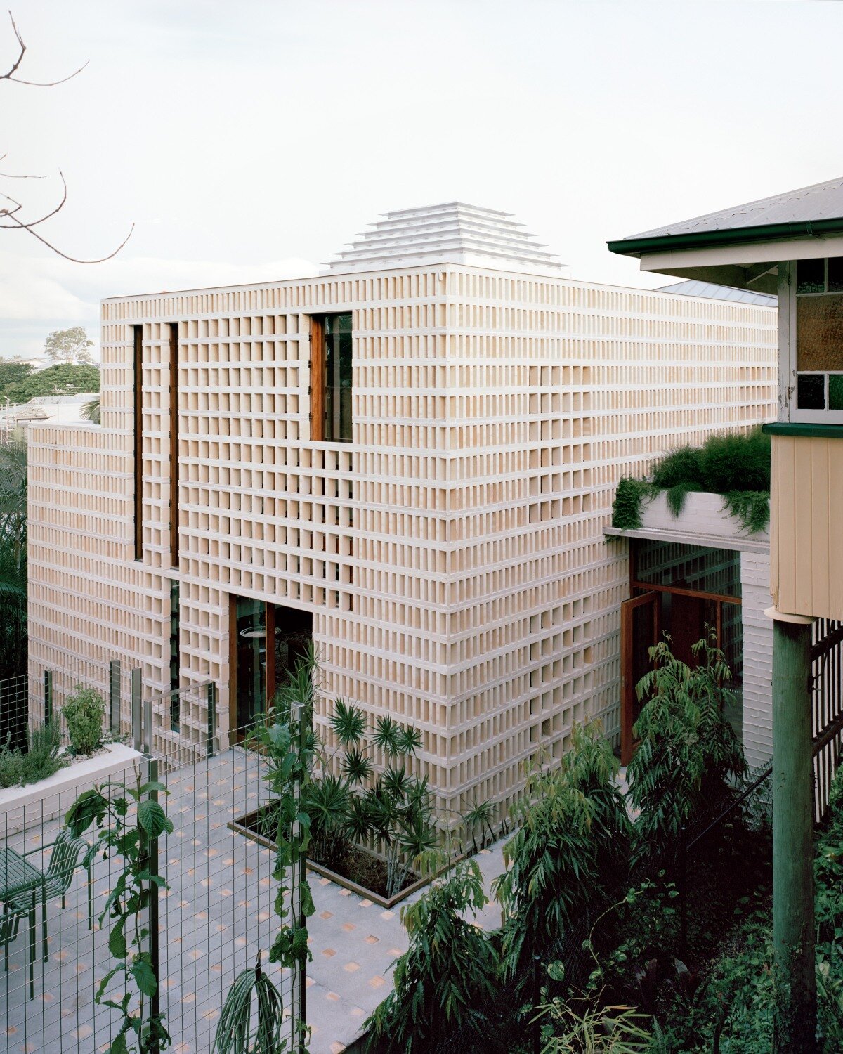 salvaged terracotta, bricks, and metal nets wrap around peter besley's australian house