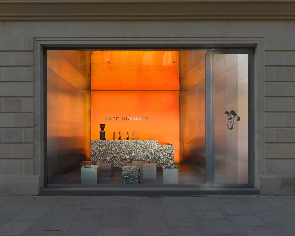 warm orange glow bathes crosby studios' chromatic café in paris 