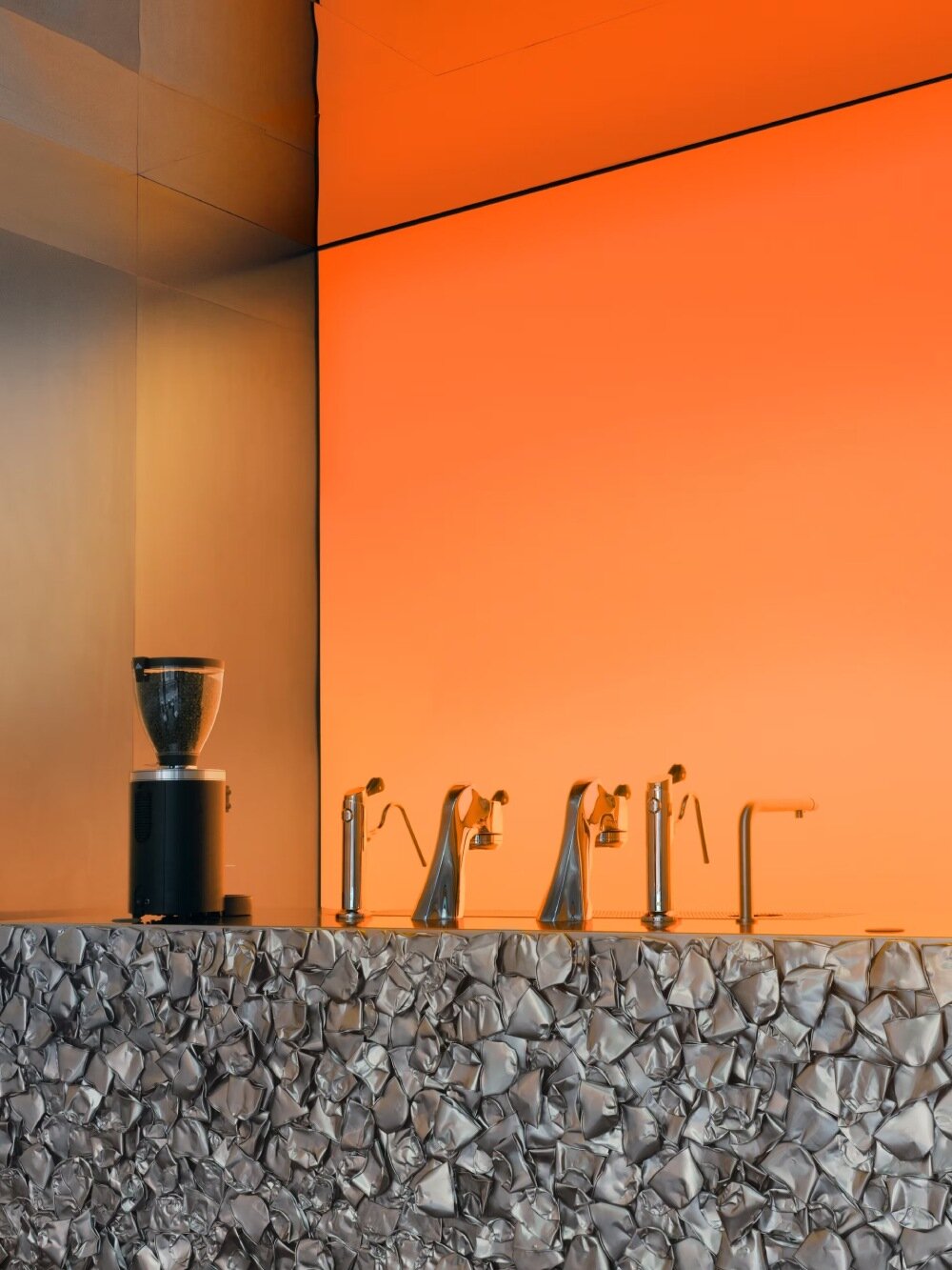 warm orange glow bathes crosby studios' chromatic café in paris 