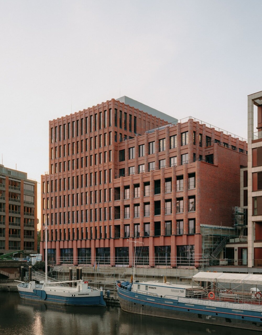 semi-circular red bricks clad christ & gantenbein's hamburg complex in rhythmic pattern
