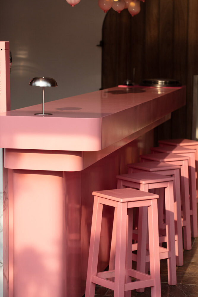 a pink-hued bar anchors the restaurant