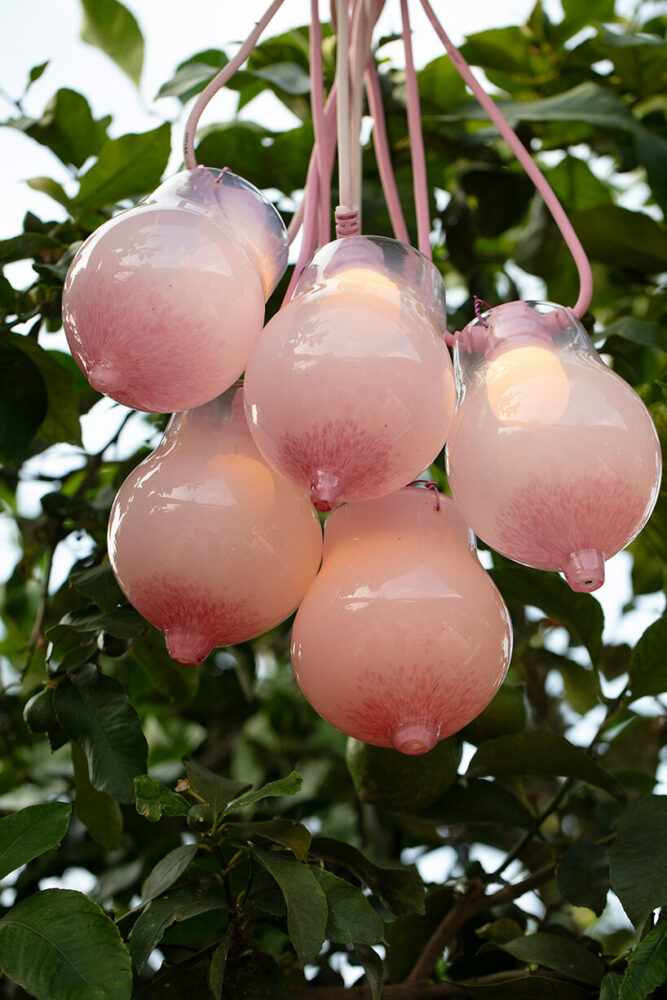 blown-glass lanterns shaped like abstracted breasts hang above 