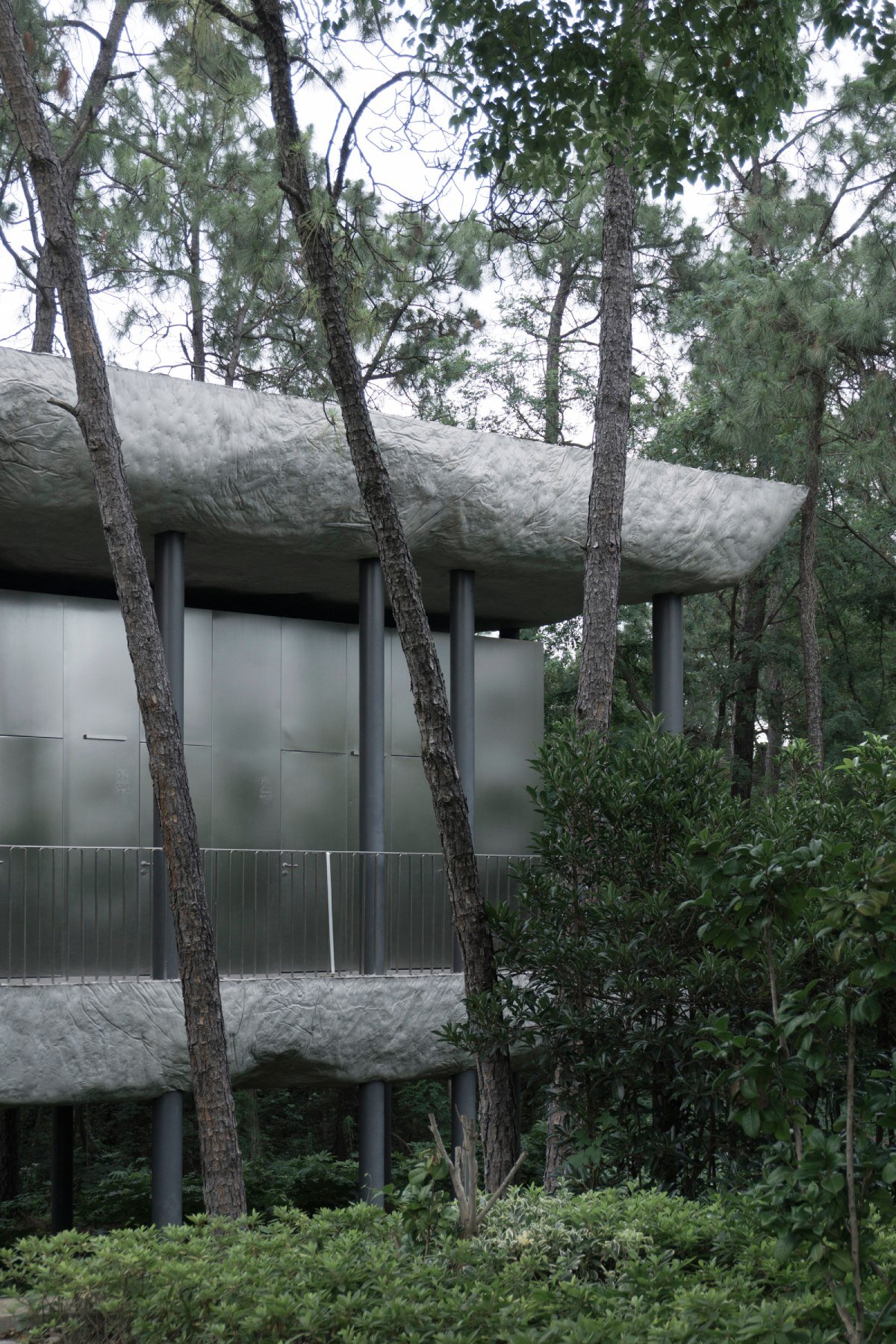WUWU atelier's restrooms perch like concrete clouds and cavernous crevices in china forest
