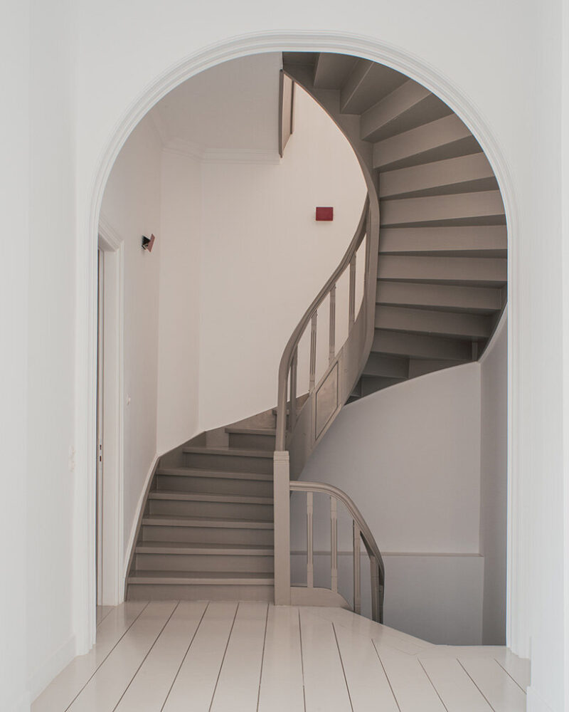 the formerly dark, rustic finish of the staircase was lightened with a soft grey