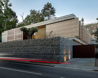 artequitectos' CL house pairs gabion walls with a travertine facade in portugal