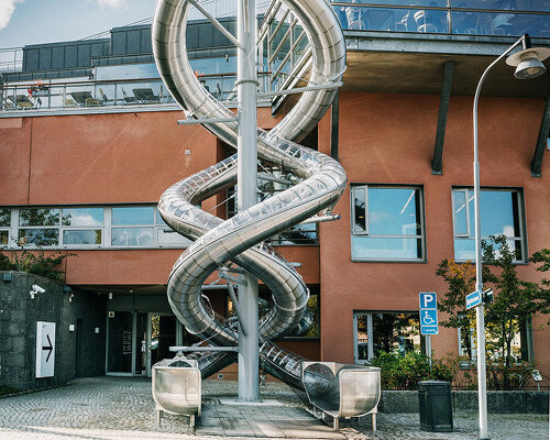 carsten höller’s mirrored slides spiral down facade of moderna museet in stockholm
