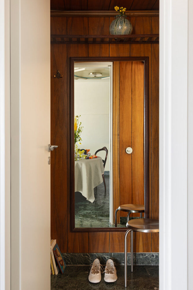 restored wood paneling and marble flooring mark the transition between rooms