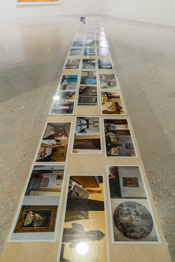 table installation featuring photographic prints arranged in a linear composition | image ©Andreas Simopoulos