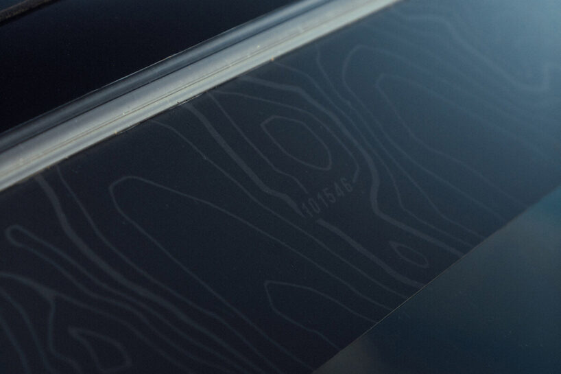 the car’s windshield banner hides a topographic map of the Teton range