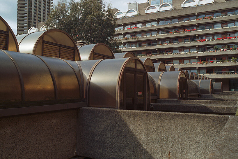 balconies are filled with red flowers, potted plants, and the everyday objects of residents