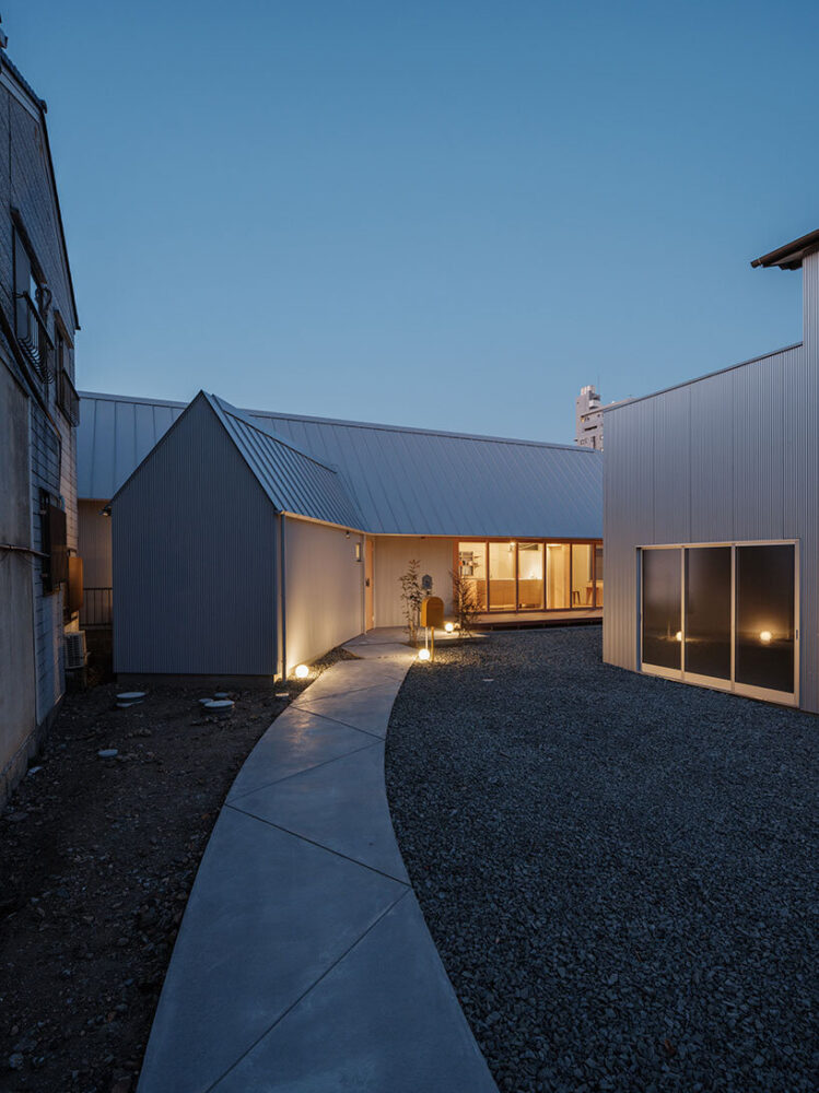 the clean exterior walls stand in quiet contrast to the dark landscape