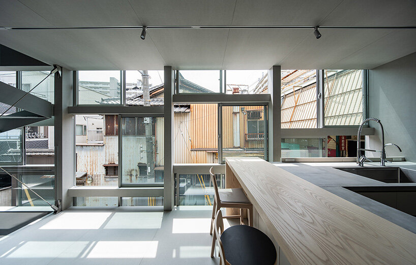 floor-to-ceiling glazing frames the everyday life of the neighboring shopping arcade