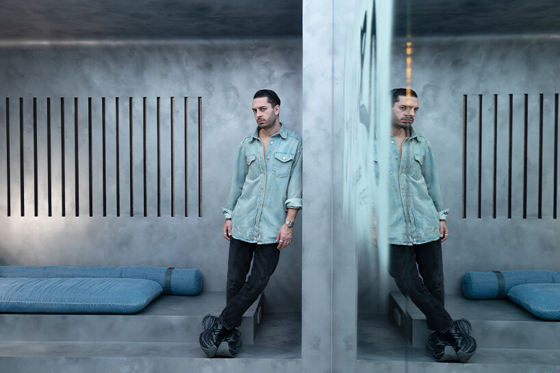 designer Gabriel Askenazi stands on the nook between the mirror and the sitting area
