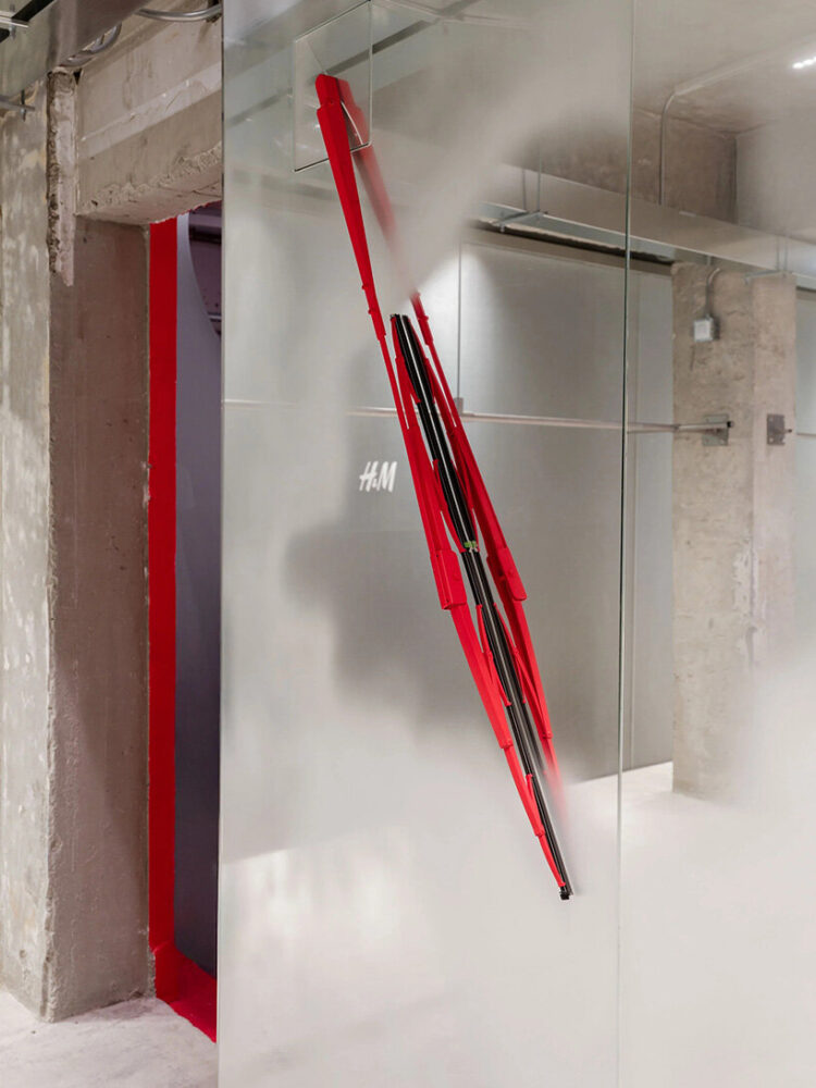 a windshield-wiper installation animates a mirrored wall