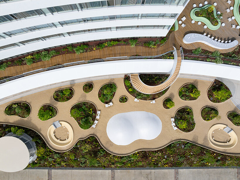 curving paths, planting beds, and terraces echo the building’s geometry