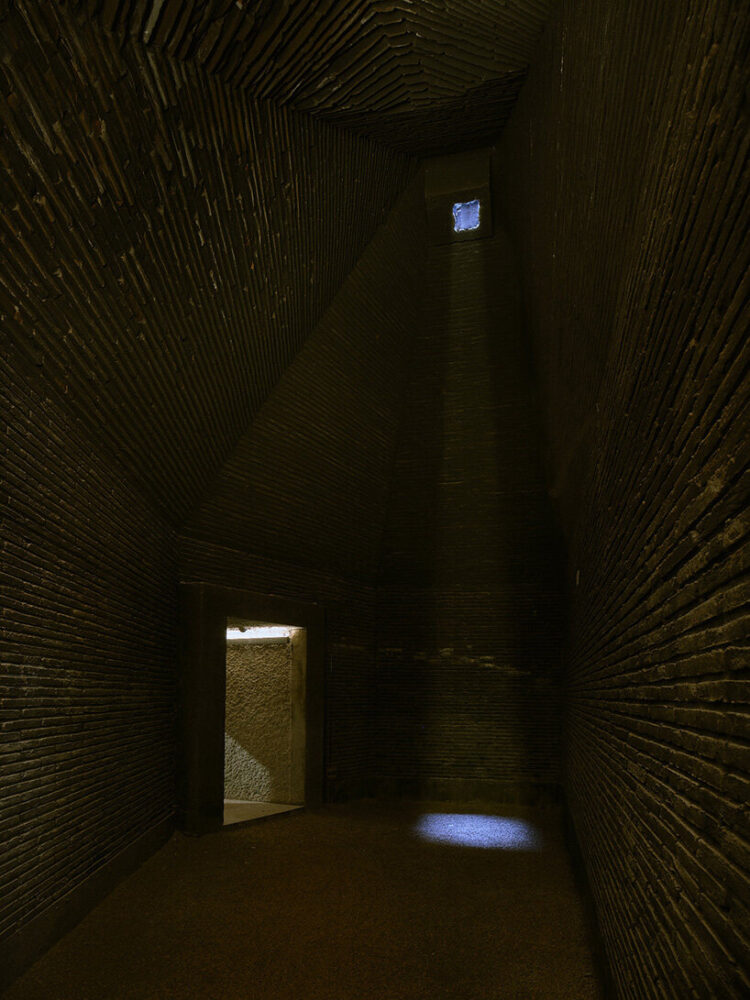 a linear vaulted passage guides visitors through alternating zones of shadow and daylight