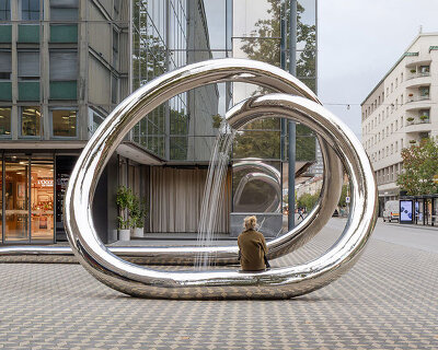 continuous steel loop forms water sculpture reflecting ljubljana’s urban fabric