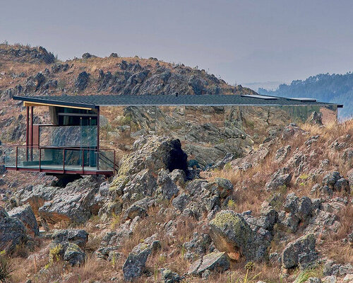 reflective glass surfaces mirror the rocky terrain across andean cabin by rtresarquitectos