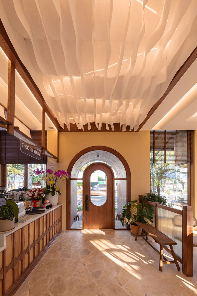 the main entry is articulated as a softly lit archway set within thick, textured walls