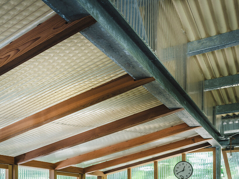 corrugated roofing and polycarbonate panels overlap to form a layered, climate-responsive ceiling
