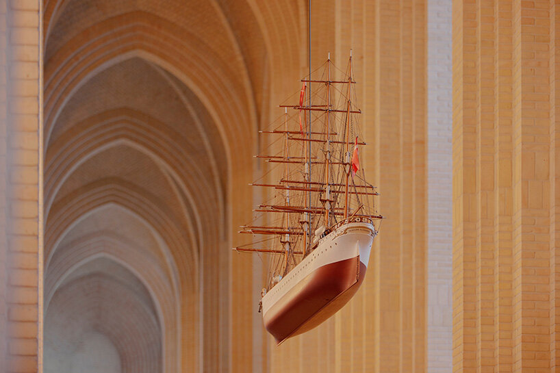 a model ship hangs beneath the brick vaults