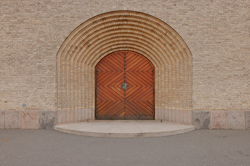 the main entrance door is framed by concentric brick arches