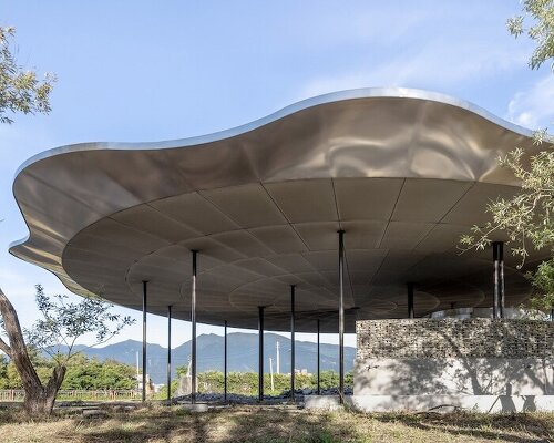 metal lotus roof of tie-ma cycling station floats next to taiwan’s dapo pond