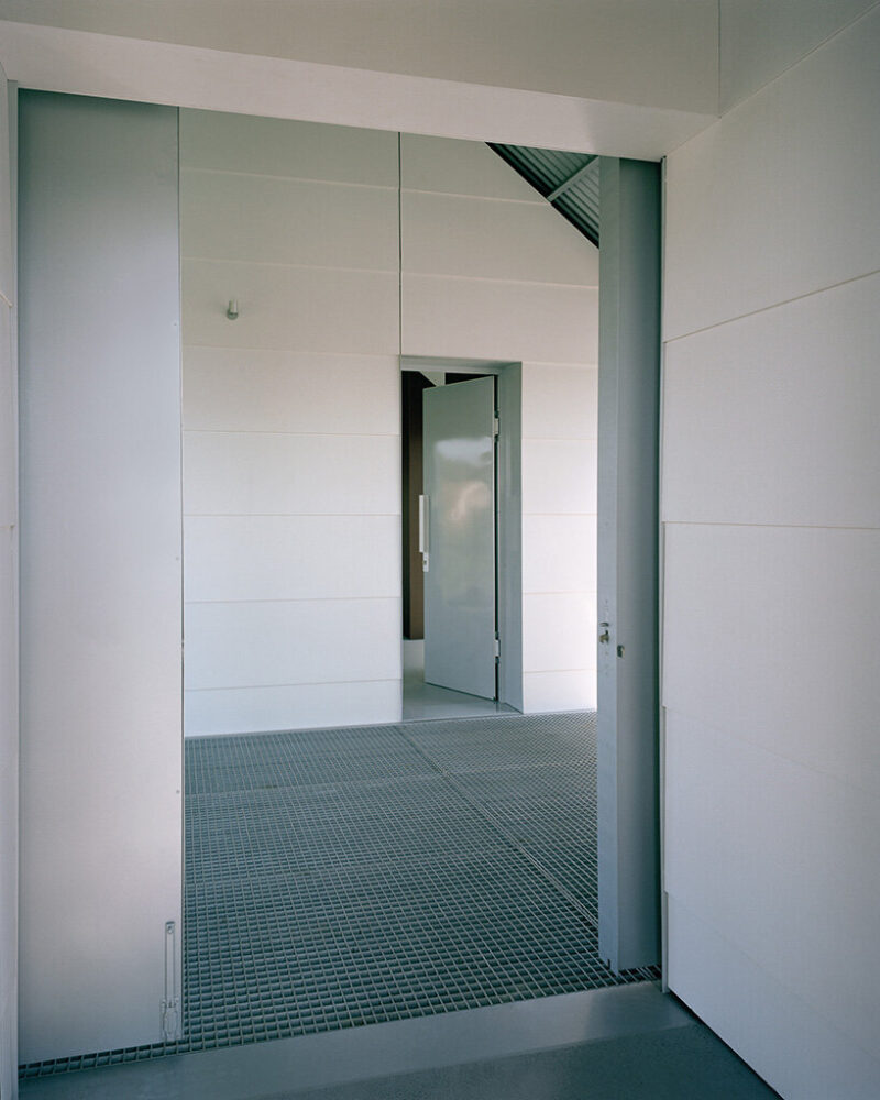 the gridded metal deck mediates between interior threshold and exterior ground