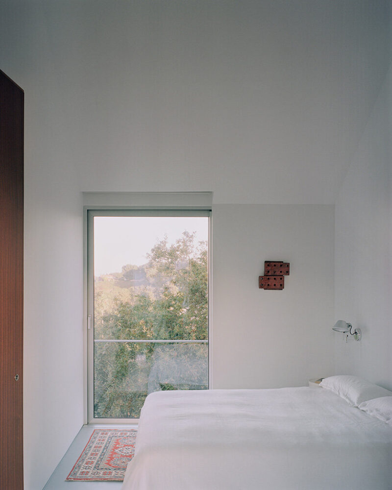 a compact bedroom opens directly toward the surrounding greenery