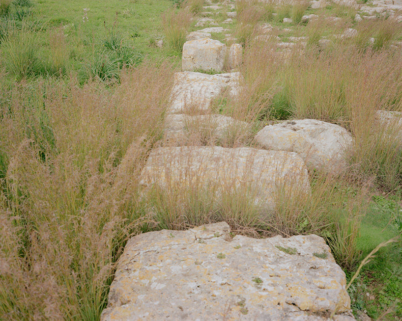 remnants of ancient stone structures emerge through grasses in the Pantalica Valley