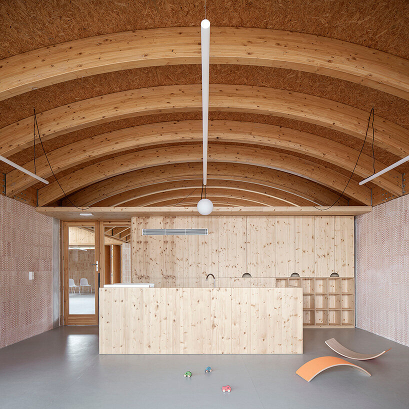 curved laminated timber beams generate the vaulted ceiling across the classroom spaces