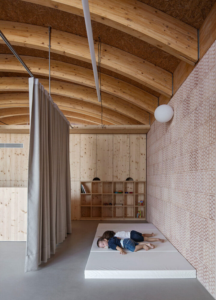 exposed timber vaults and patterned tiles shape a calm resting space for children